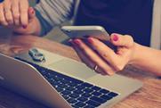Person using a smartphone and laptop
