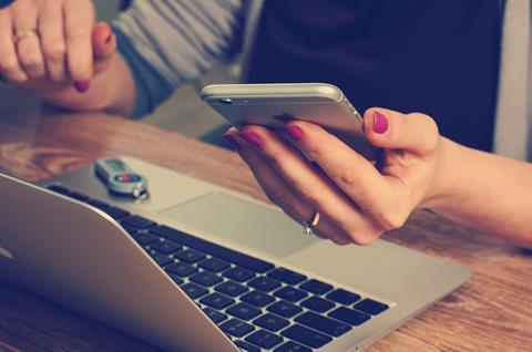 Person using a smartphone and laptop